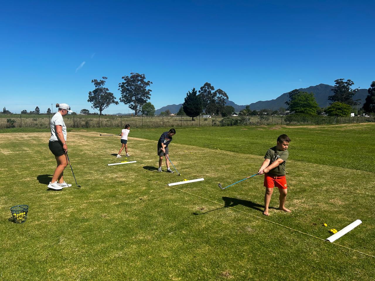 Professional golf instruction with mountain backdrop